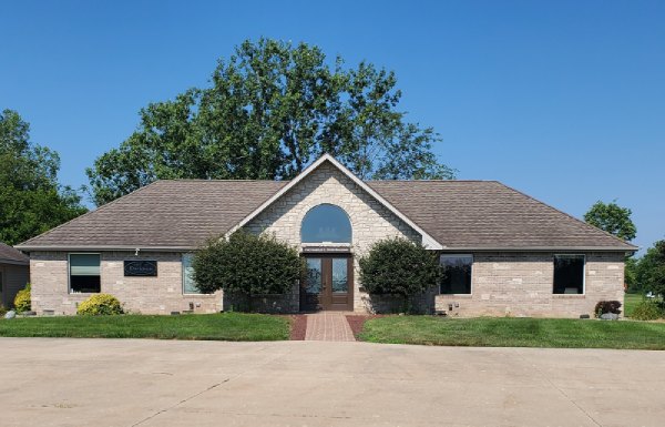 The Dyer Real Estate office: a single-story stone building with a peaked entryway and arched window, set back from South Park Avenue.
